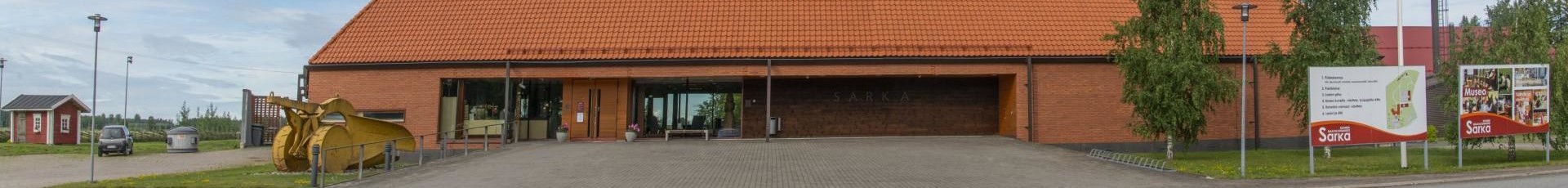 Museorakennuksen sisäänkäynnin seinä ja punainen tiilikatto