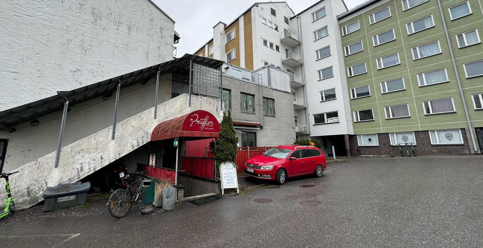 Proffan kellarin sisäänkäynti kerrostalon pihalla sateisena päivänä