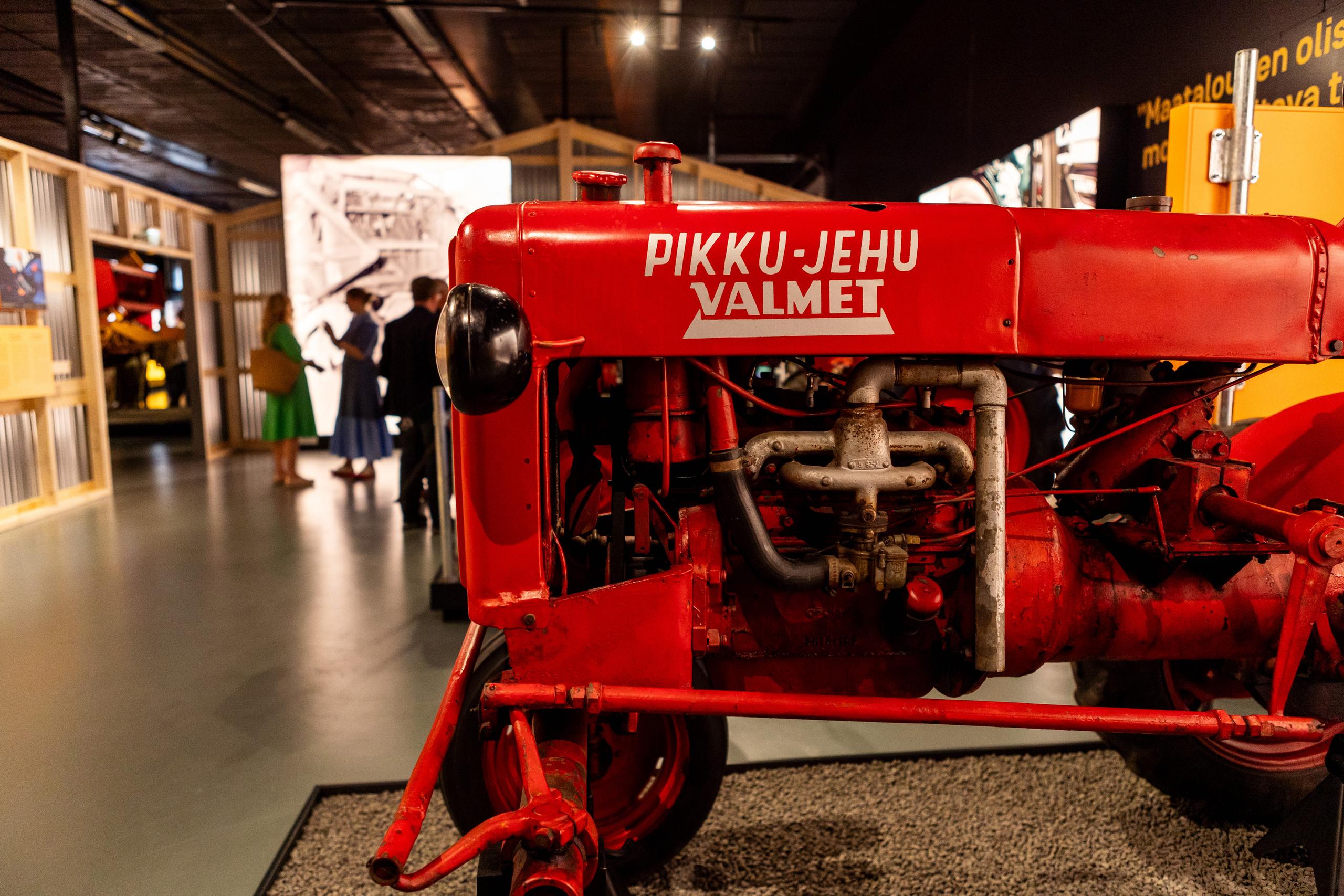 Punainen Valmet-Pikku-Jehu-traktori näyttelyssä, taustalla vierailijoita